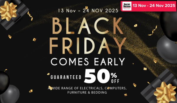 Man in a gray blazer over a dark gray shirt standing on stairs in an urban background.